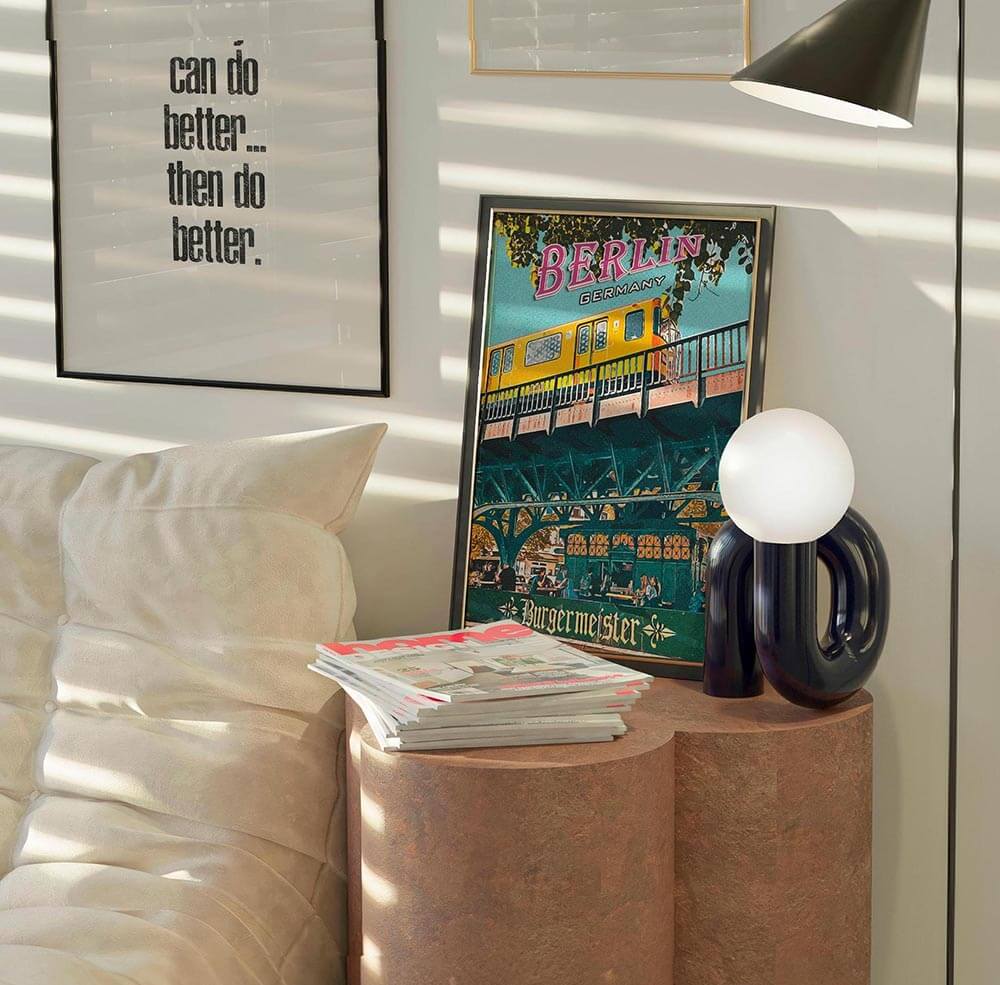 Berlin poster leaning on a stone side table beside a black globe lamp in warm afternoon light