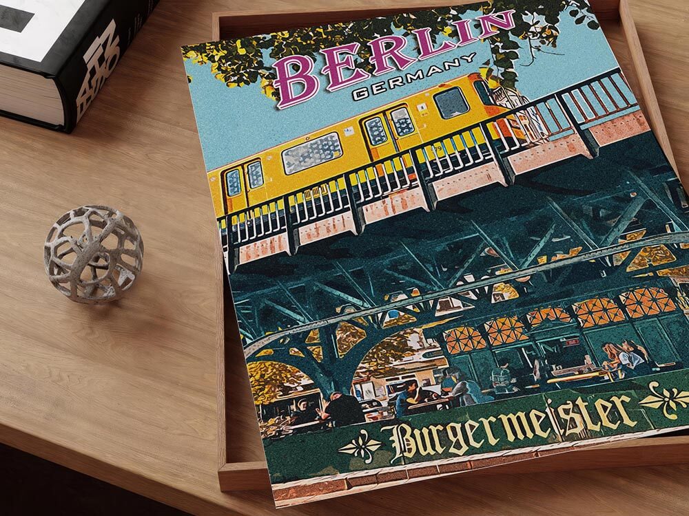Close up of the Berlin poster in a wooden tray showing textured paper, yellow train and gothic Burgermeister lettering