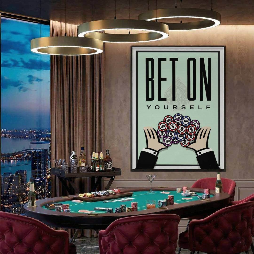 Large framed Bet On Yourself art print above a green felt poker table in a penthouse game room