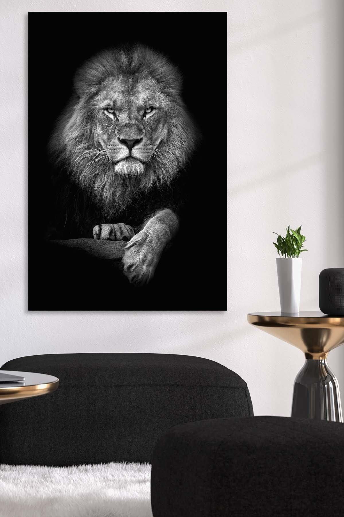 Large black and white lion canvas on a white wall beside a brass side table and black boucle seating