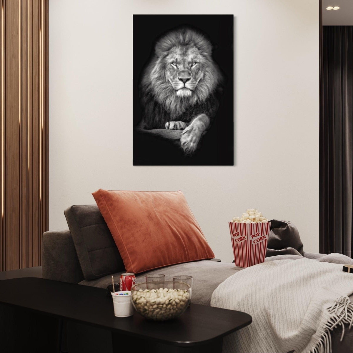 Grayscale lion canvas above a grey lounge sofa with rust cushion and popcorn in a cozy media room