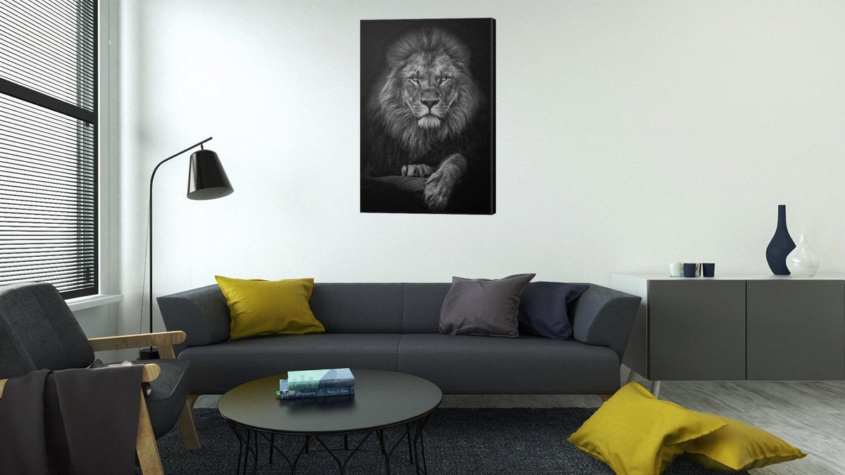 Black and white lion canvas on a white wall above a charcoal sofa with mustard yellow cushions