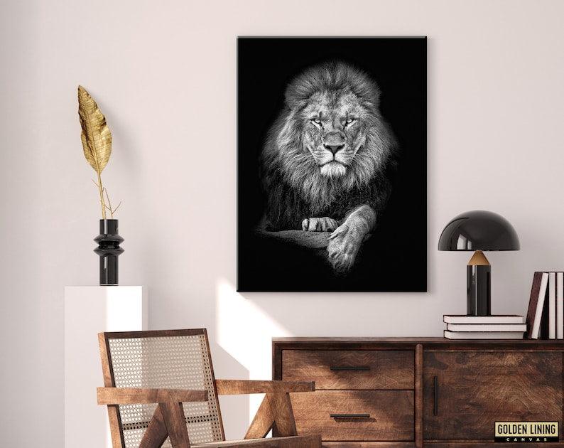 Black and white lion canvas on a soft neutral wall above a wooden sideboard and cane chair