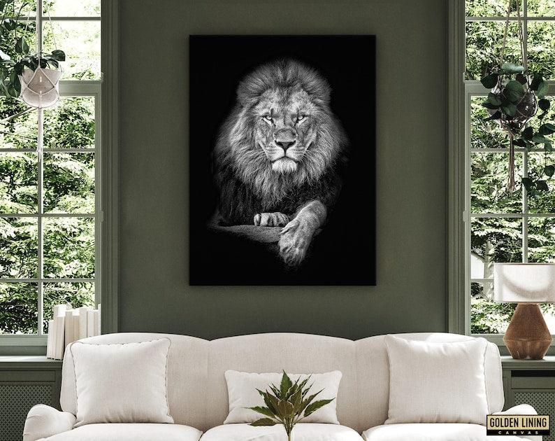 Monochrome lion canvas on a deep olive green wall above a cream sofa between two garden windows