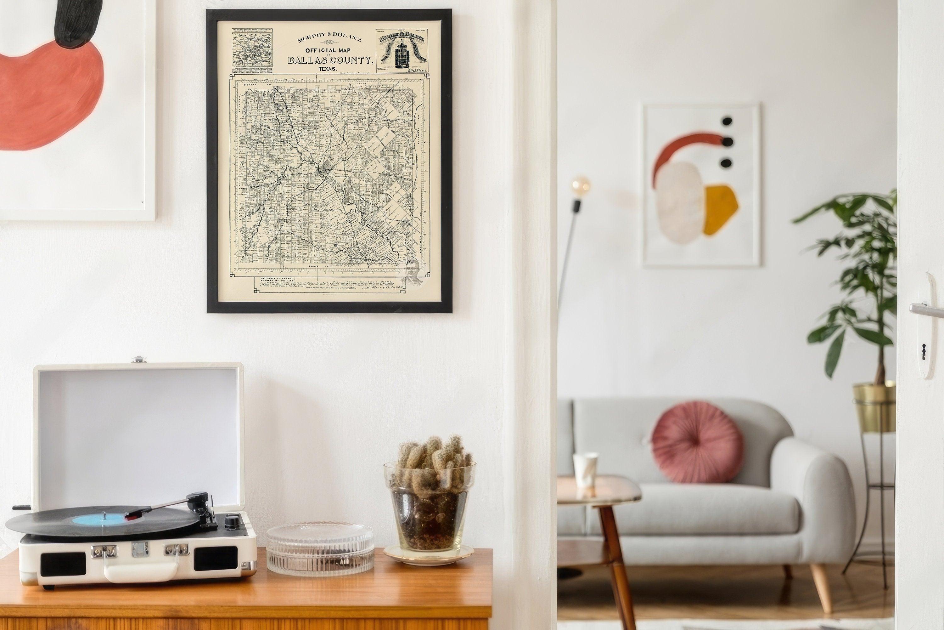 Black framed vintage Dallas County map hanging above a record player in a bright mid century room