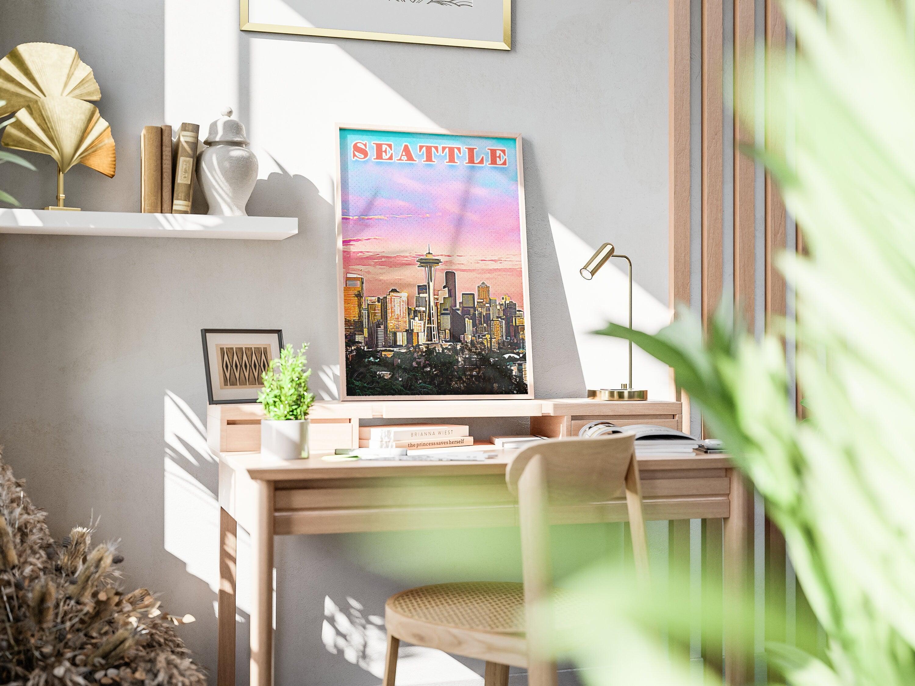 Pink and orange Seattle skyline art leaning on a desk in warm afternoon light, front view